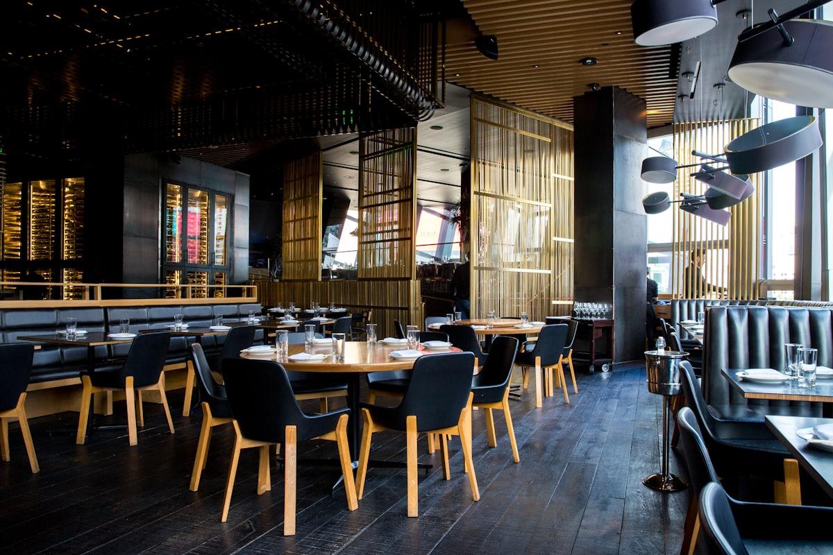 Server carrying plates through a busy restaurant